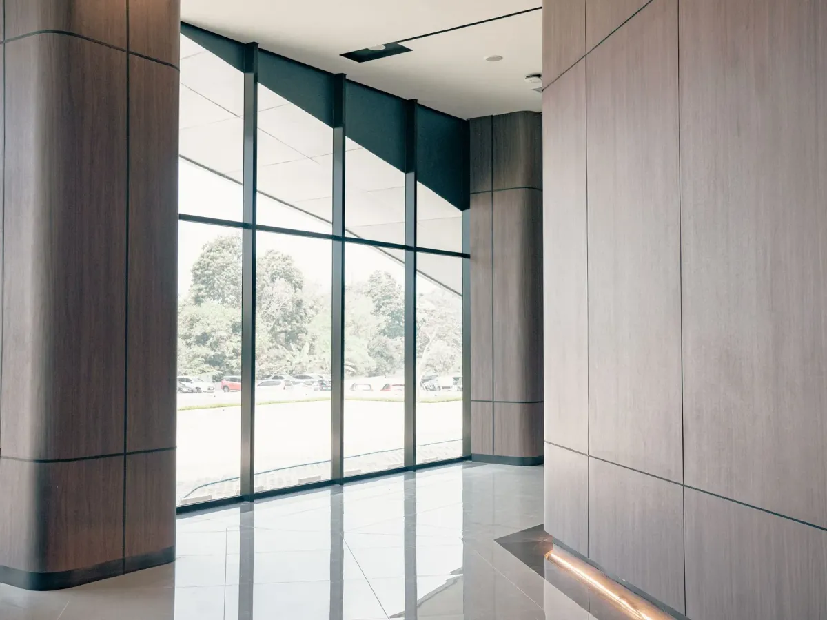 A clean, bright entrance hall with wood-panelled columns and floor-to-ceiling windows