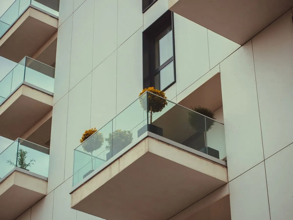Glass balconies with potted plants on a modern residential building