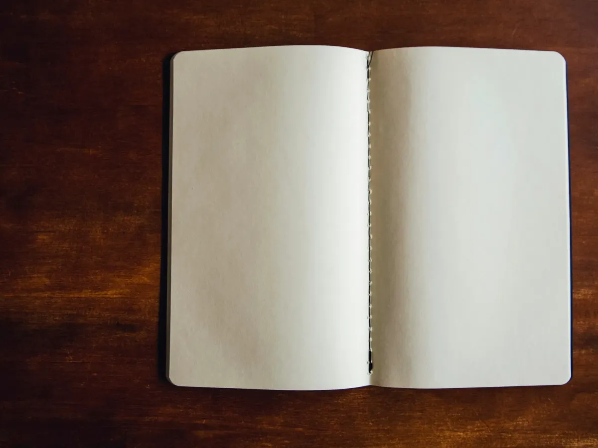 Open notebook with blank pages on a wooden table
