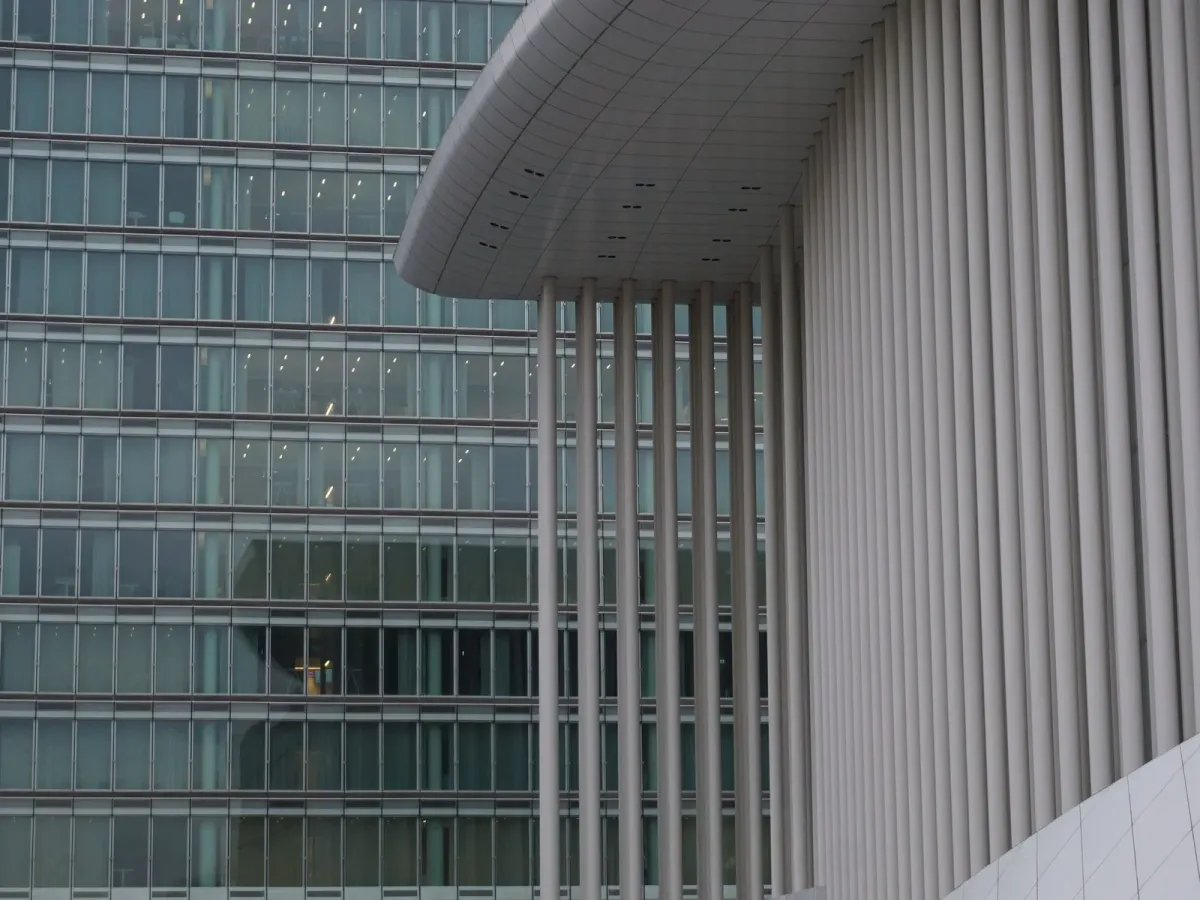 The white columns of the Philharmonie in Kirchberg beside a glass office tower
