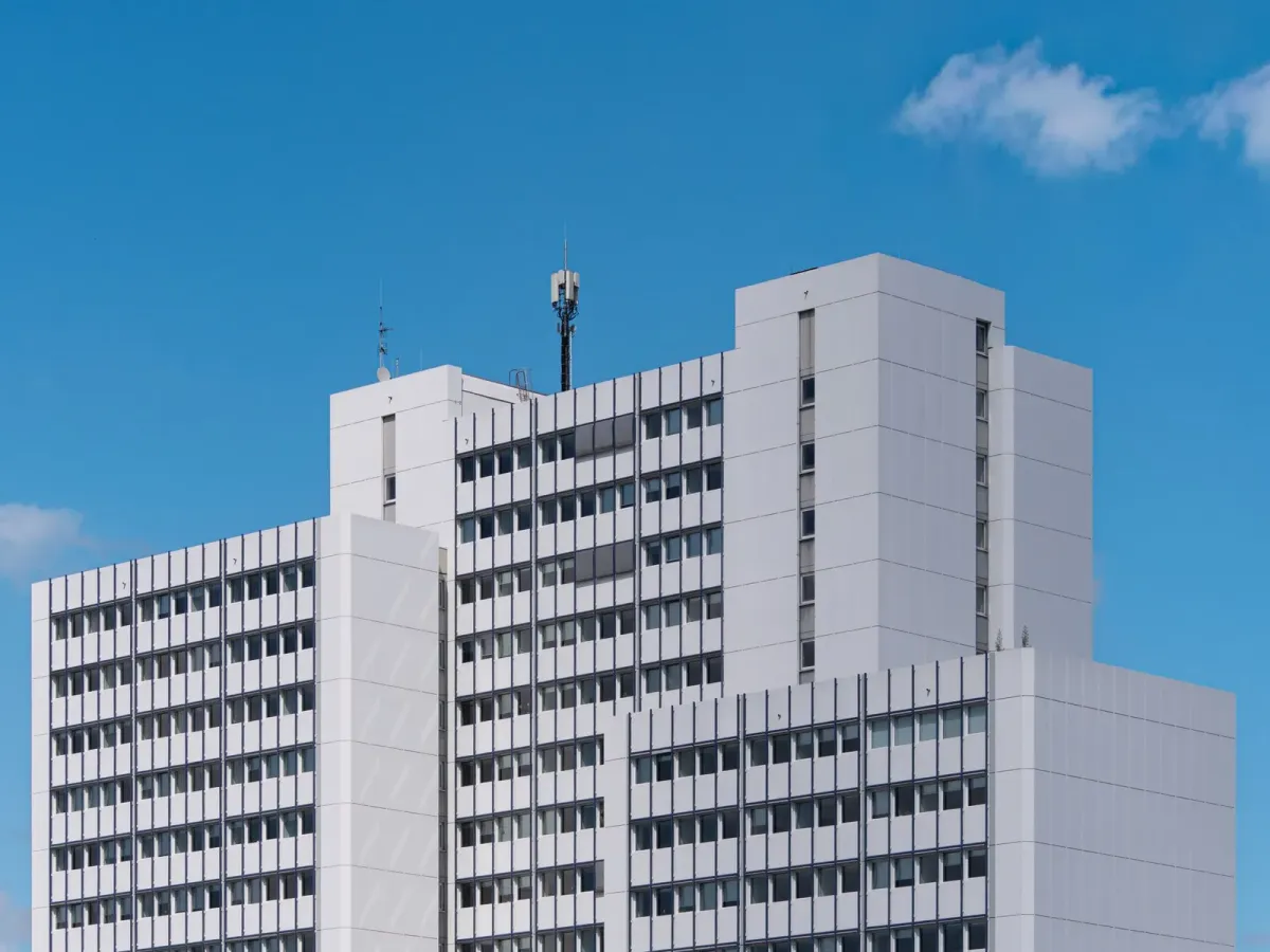 Immeuble de bureaux blanc aux nombreuses fenêtres, sous un ciel bleu