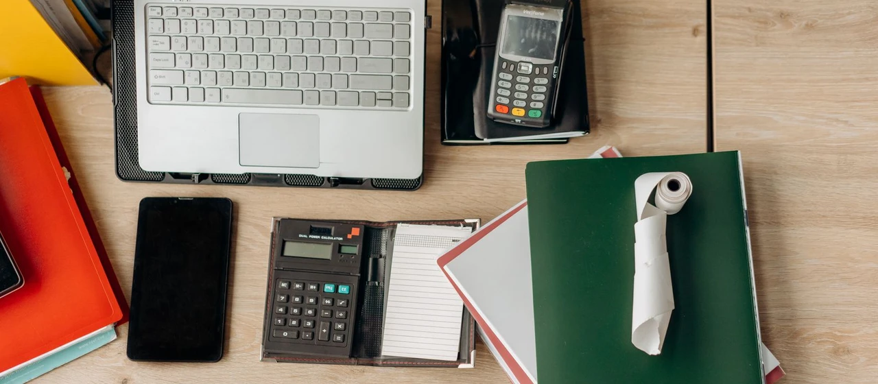 Bureau organisé avec ordinateur, calculatrice et documents pour illustrer la facturation au Luxembourg