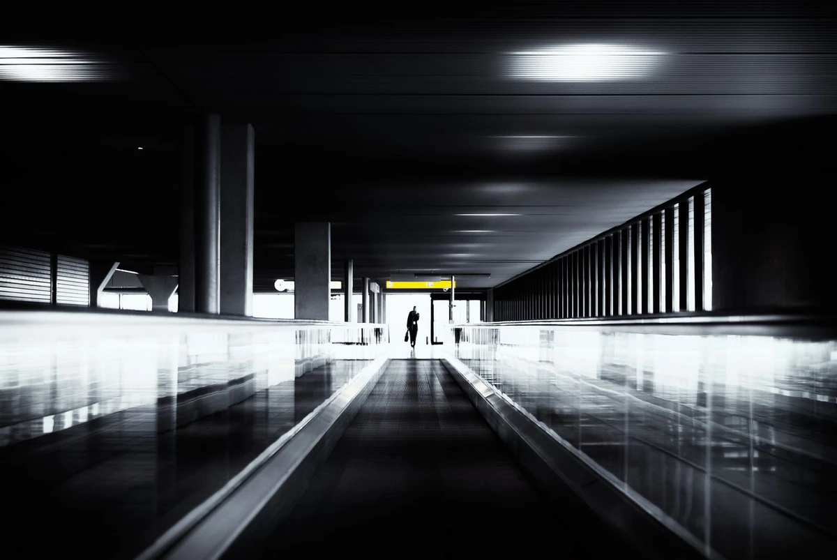 Business traveller walking through a modern airport corridor, evoking an executive relocation to Luxembourg