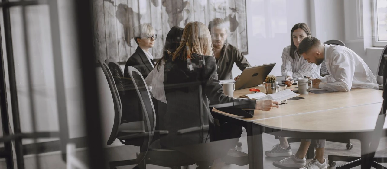 A professional team meeting illustrating the first employee hired by a Luxembourg company