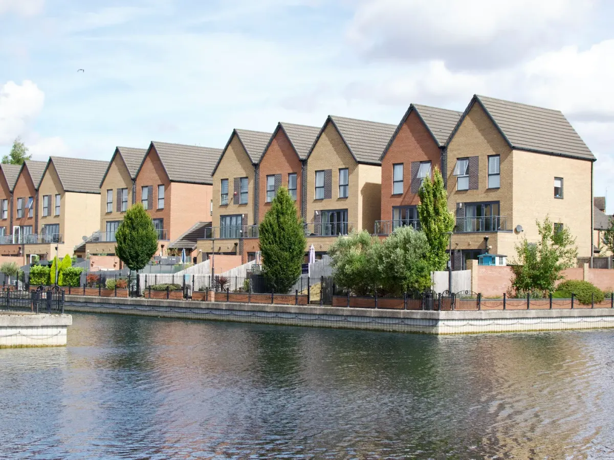 A row of modern townhouses facing a calm stretch of water