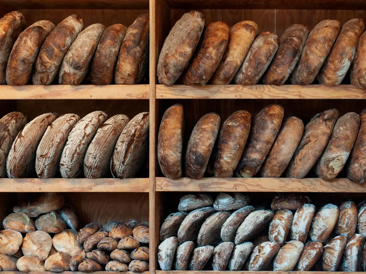 Pains d’artisan alignés sur les étagères en bois d’une boulangerie