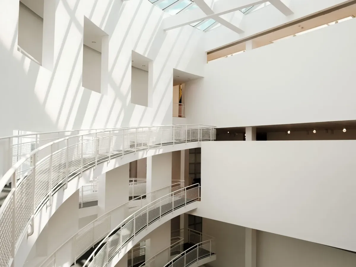 Curved white walkways circling a bright atrium beneath a skylight