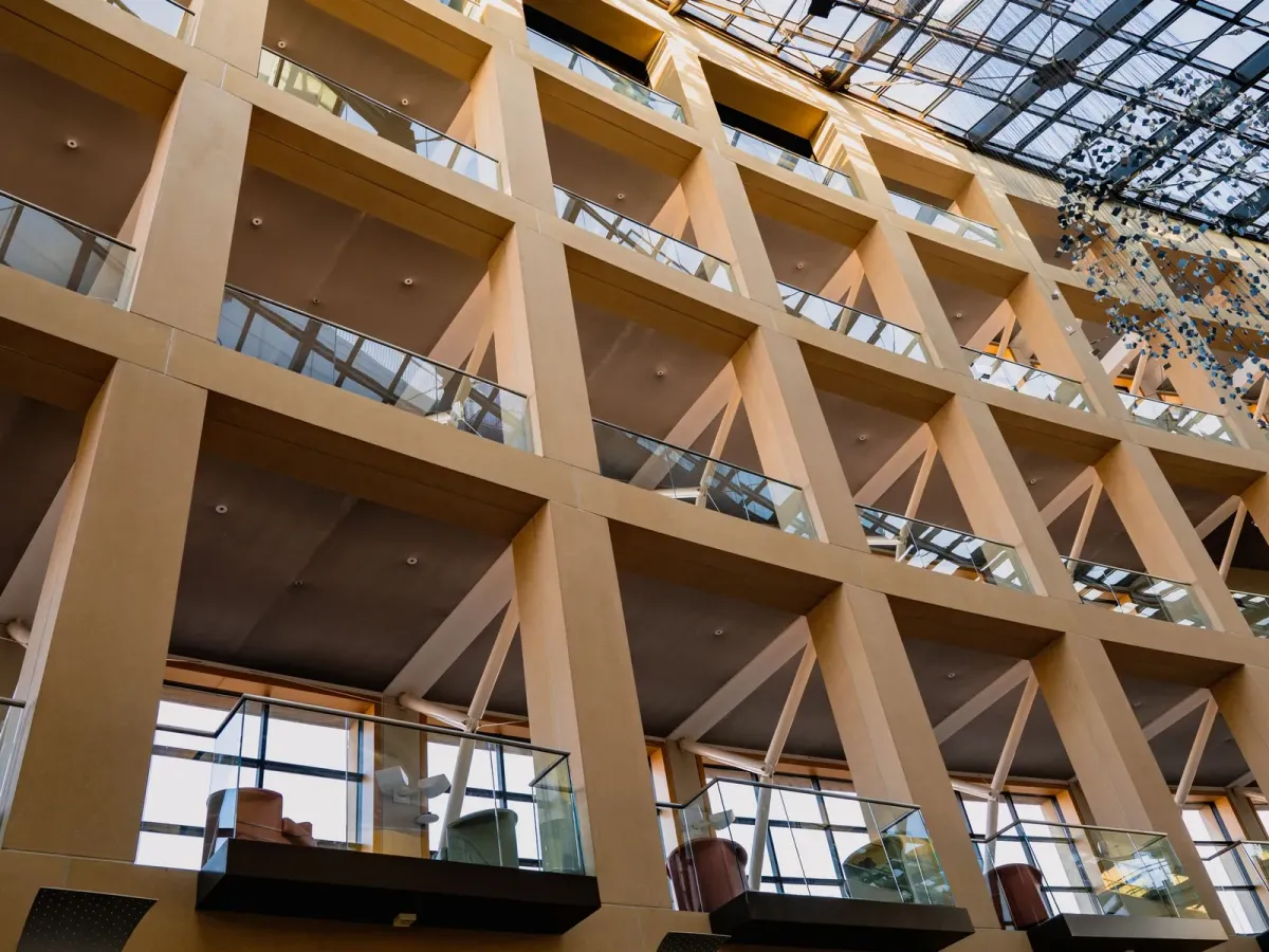 Galeries et garde-corps vitrés autour d’un atrium couvert d’une verrière