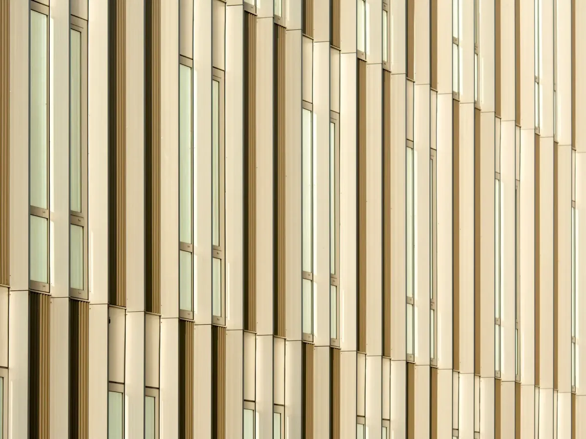 A modern facade with tall windows set between champagne-coloured vertical panels