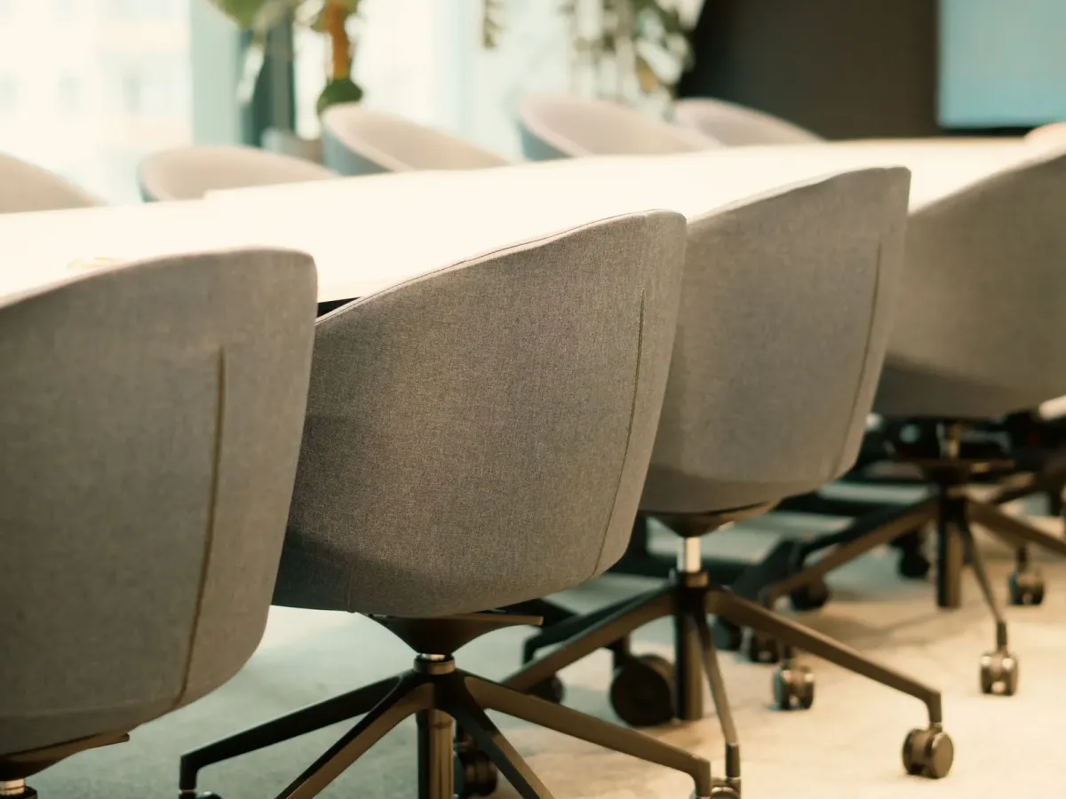 Grey upholstered chairs along a white conference table
