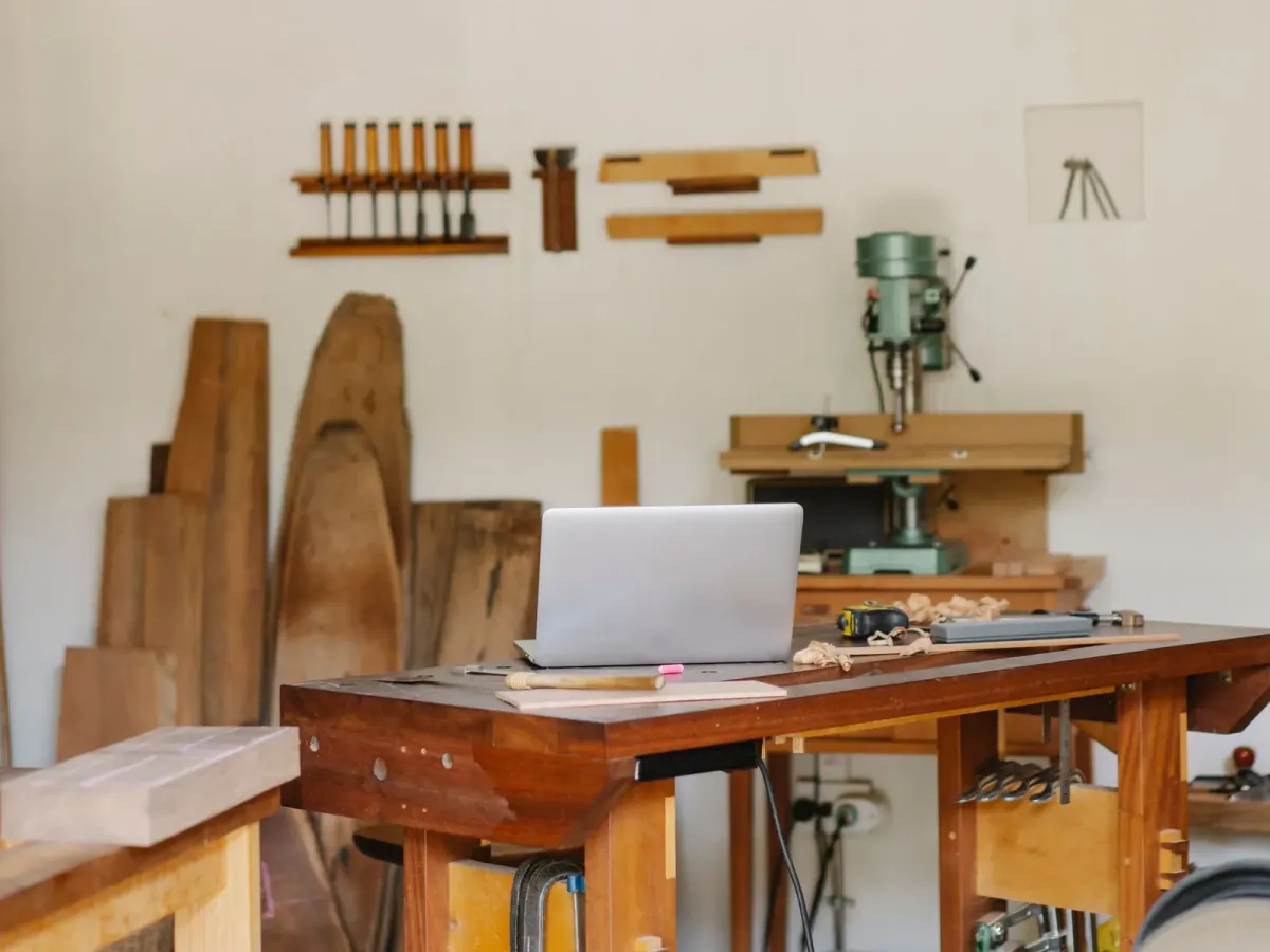 Atelier de menuiserie lumineux, avec un établi, un ordinateur portable et des planches de bois