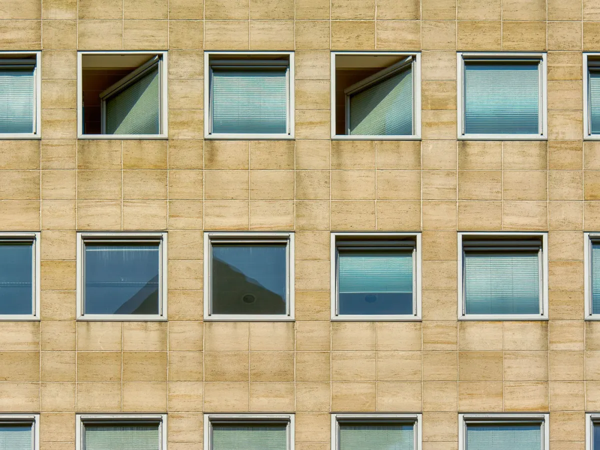 Façade d’immeuble de bureaux en pierre claire, rythmée de fenêtres régulières