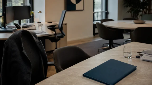 Bureau en activité avec postes de travail, dossier et salle de réunion préparée